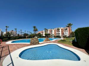 萨阿拉德洛斯阿图内斯Marina Zahara的棕榈树和建筑度假村内的游泳池