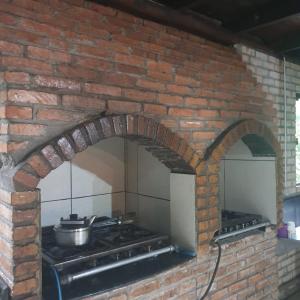 GuabirubaSitio do Sol quarto wc compartilhado的砖炉,上面有锅