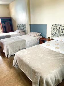 巴克里索莫雷诺港Kicker House的带3张白色床单的床的房间