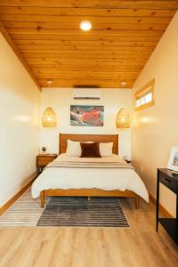 帝王鲑The Lodge at 58* North的一间卧室设有一张床和木制天花板