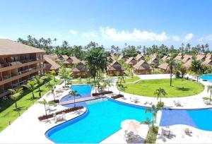 塔曼达雷Flat praia dos carneiros eco resort 26的享有带游泳池的度假村的空中景致