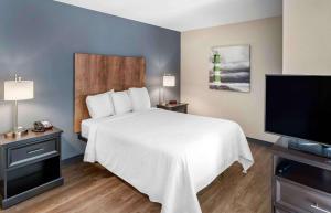 圣何塞Extended Stay America Premier Suites - San Jose - Airport的一间卧室配有一张床和一台平面电视