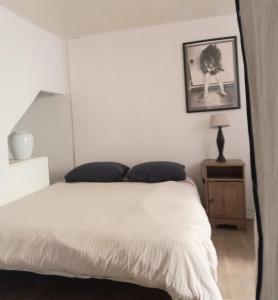 阿维尼翁Le Nid的卧室配有白色的床,墙上挂着一幅画
