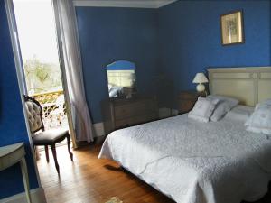 Saint-Félix莱斯艾瑞斯别墅酒店的蓝色卧室,配有床和椅子