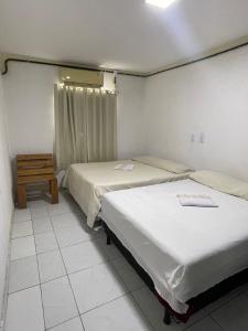 巴雷里尼亚斯Pousada Cactus的一间卧室配有两张床和一张桌子