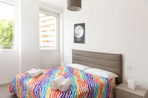 米兰Van Gogh Exclusive Apartment的一间卧室配有一张色彩缤纷的床和毛巾