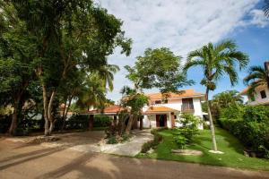 圣佩德罗-德马科里斯Villa At Metro Country Club With Private Pool的前面有棕榈树的房子