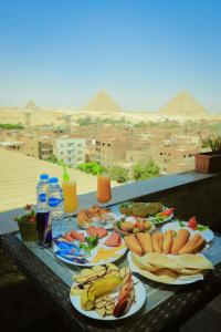 开罗King Khafren View INN的一张桌子,上面有金字塔,上面有盘子