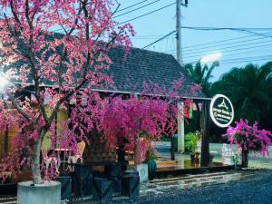 Ban Ton Liangกอบสุข รีสอร์ท2 k13的一座建筑物前有粉红色花的树
