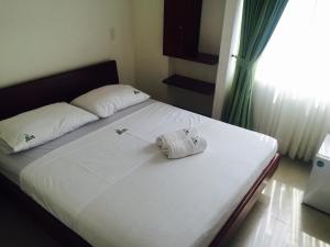 布卡拉曼加优选典雅酒店的一张带白色床单和毛巾的床