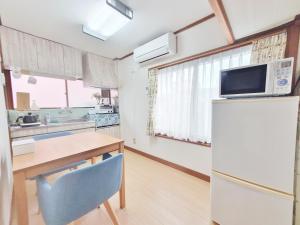 鸟取市Whole house rental 一棟貸切宿 "Your Home Tottori" 市内中心地近くの素敵な一軒家的厨房配有冰箱和带微波炉的桌子。