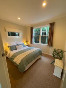 帕拉帕拉乌穆Refined, Retro & Relaxing的一间卧室设有一张大床和两个窗户。