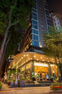 胡志明市Northern Charm Hotel的商店前灯火通明的大建筑