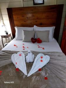 GuabirubaSitio do Sol suíte romântica的床上有两件衣服和鲜花