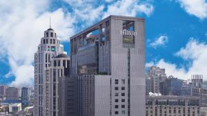 台北台北新板希尔顿酒店的一座高大的建筑,在城市里,上面有摩尔顿标志