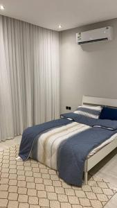利雅德Luxury Apartment的一间卧室配有一张带蓝色床单的大床