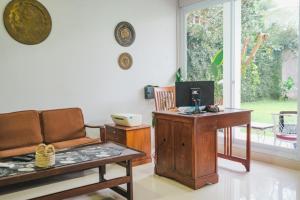斯勒曼Villa Prambanan Jogja with Private Swimming Pool by Simply Homy的带沙发和书桌的客厅