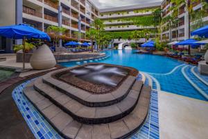 芭东海滩Deevana Plaza Phuket - SHA Extra Plus的一座带蓝伞的酒店游泳池