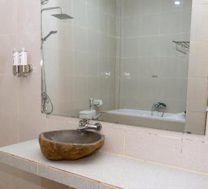 纳闽巴霍Green Prundi Hotel的带淋浴和浴缸的盥洗盆的浴室