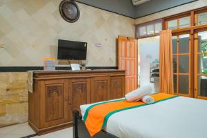 日惹Homestay Simply Homy Jogja dekat Gembira Loka Zoo的一间卧室配有一张床和一台平面电视