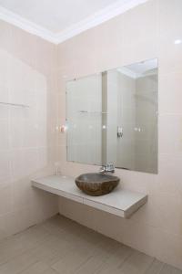 纳闽巴霍Green Prundi Hotel的一间带水槽和大镜子的浴室