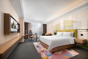 南宁南宁江南希尔顿欢朋酒店的酒店客房设有一张大床和一张书桌。