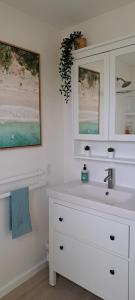 Head of BayConch Club Cottage的白色的浴室设有水槽和镜子