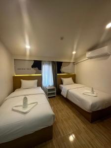 琅勃拉邦Midnight Blue Guesthouse的客房设有两张床和窗户。