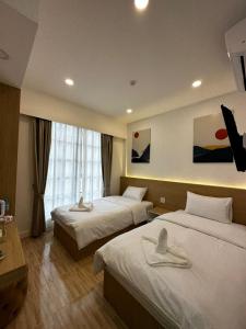 琅勃拉邦Midnight Blue Guesthouse的酒店客房设有两张床和窗户。