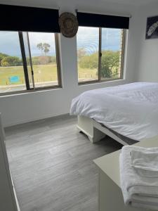 WoorimOceanview的一间卧室设有一张床和两个美景窗户。