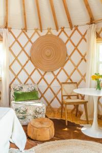 奥斯汀Camposanto Glamping - The Peacock Yurt的配有带椅子和桌子的蒙古包的客房