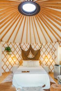 奥斯汀Camposanto Glamping - The Peacock Yurt的蒙古包内一间卧室,配有一张床