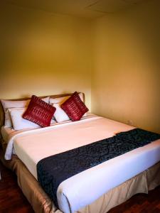 珍南海滩LANGKAWI LAGOON RESORT OCEAN SUITE的一间卧室配有一张带红色枕头的大床