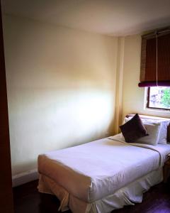 珍南海滩LANGKAWI LAGOON RESORT OCEAN SUITE的一间卧室配有一张带白色床单的床和一扇窗户。