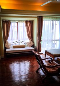 珍南海滩LANGKAWI LAGOON RESORT OCEAN SUITE的一间卧室配有一张床、一把椅子和窗户。