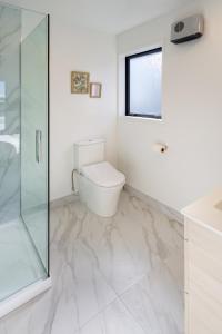 基督城Tuam Street delight 4 bed 4 bath的一间带卫生间和玻璃淋浴间的浴室