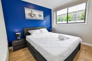 图克雷Newly Built Guest House Walk to Lake的一间卧室设有一张蓝色墙壁的大床