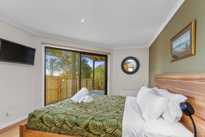 阿波罗湾阿基里斯度假屋 的一间卧室设有一张床和一个大窗户