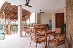 龙目岛库塔Reset Lombok Hotel的一间带桌椅的餐厅和庭院
