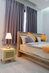 曼谷雪梨的民宿：Sukumvit 36的一间卧室配有一张床和一张带台灯的桌子