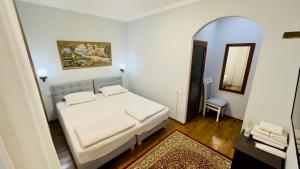 撒马尔罕Samarkand Travel Hotel的卧室配有白色的床和镜子
