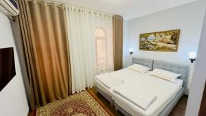 撒马尔罕Samarkand Travel Hotel的卧室配有白色的床和窗户。