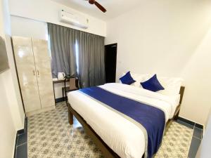 班加罗尔Felix Inn - Manyata Tech Park的一间卧室配有一张带蓝色枕头的大床