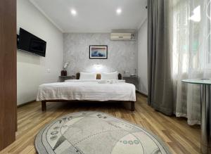 塔什干FRODO的卧室配有一张白色大床和地毯。