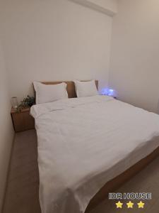 BuzăuIDR HOUSE的卧室配有一张带白色床单和枕头的大床。