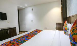 新德里FabExpress RG Stay的一间卧室配有一张带彩色毯子的床