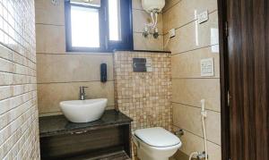 新德里FabExpress RG Stay的一间带水槽和卫生间的浴室以及窗户。