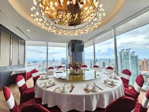 曼谷Column Bangkok Hotel的一间设有白色桌子和红色椅子的用餐室