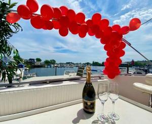 布鲁克林COZY CONDO OCEAN 3xDECK YACHT的阳台上提供一瓶香槟和两杯葡萄酒