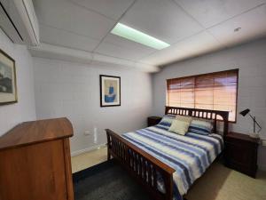 库克敦Central Comfy Holiday Unit的一间卧室配有一张床、一张书桌和一个窗户。